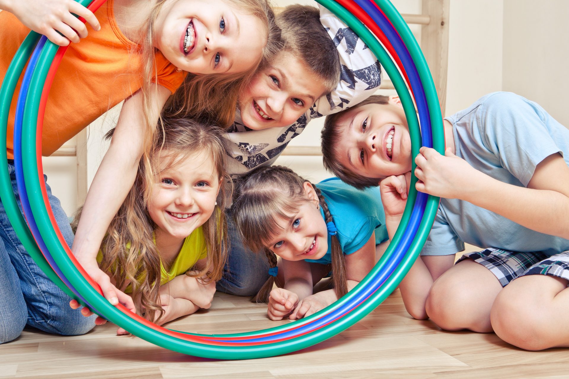 Group of smiling kids looking through gym band.