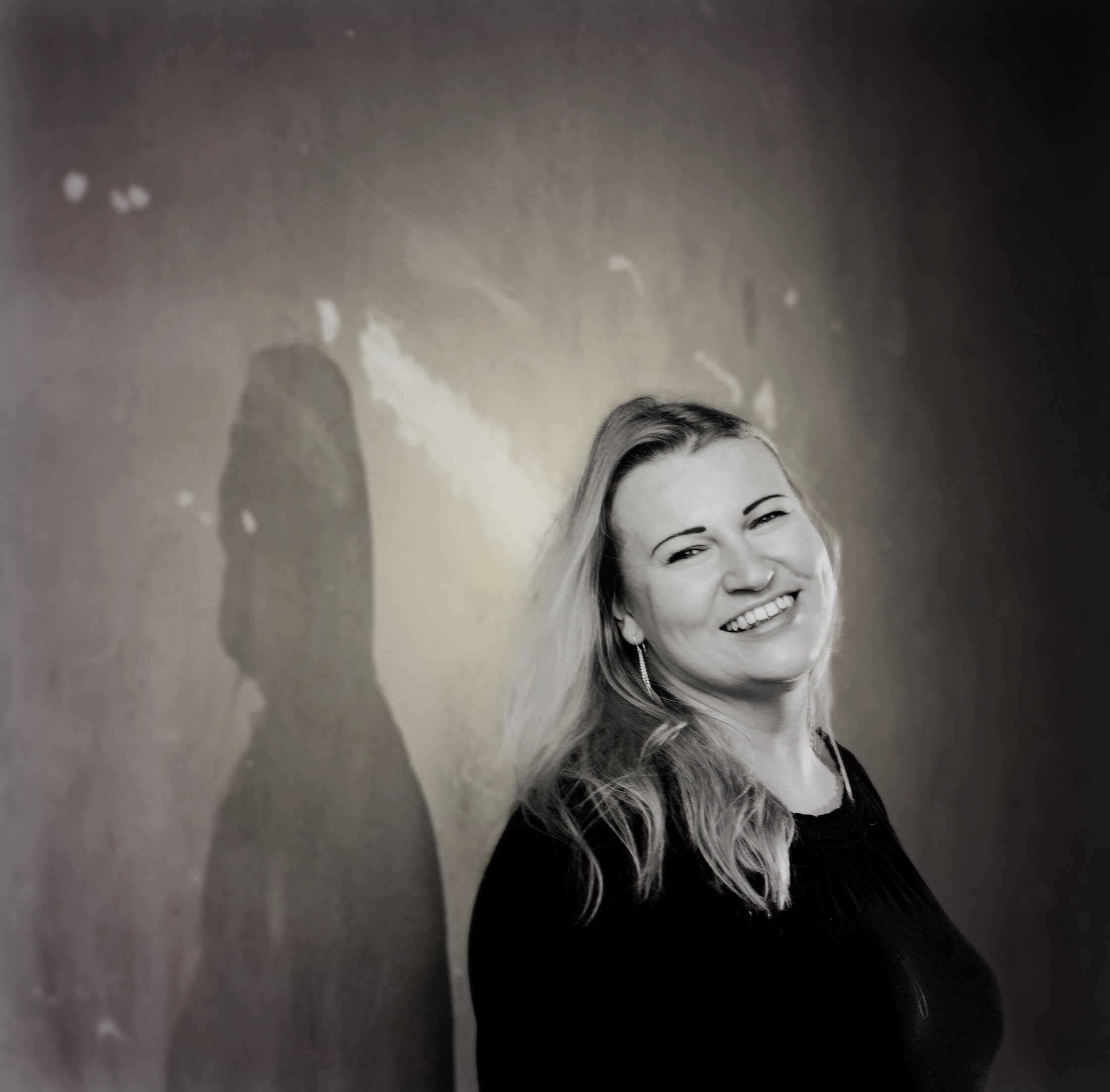 Mustavalkoinen kuva Gunta Ahlforsista, hymyilee.