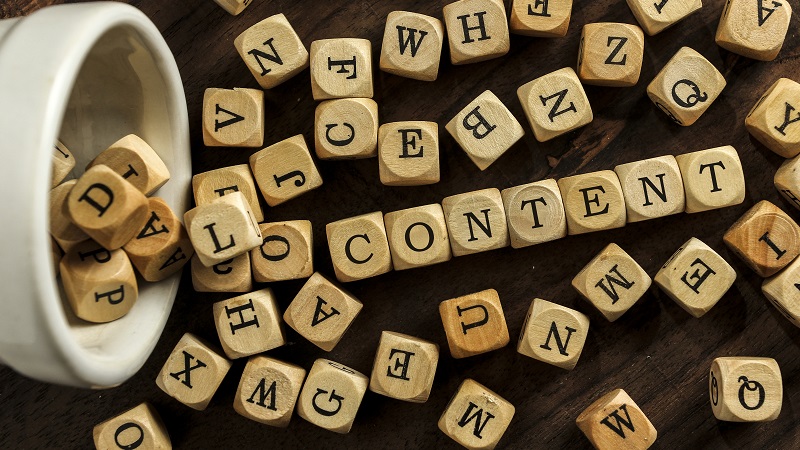 Wooden dices with letters saying content.