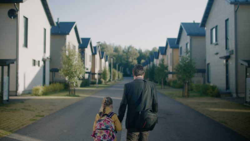 A father and a child walking hand in hand.