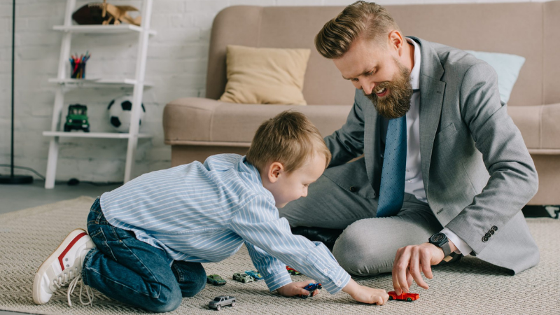 A father is playing with a child on the floor.