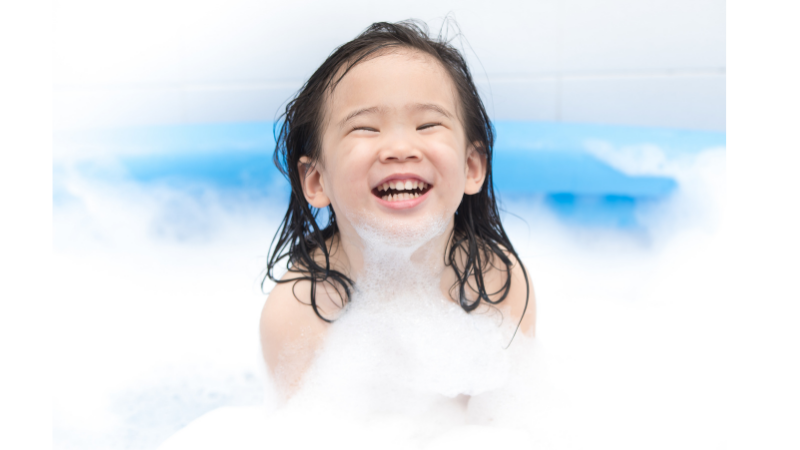 Lapsi hymyilee kylpyvaahdon keskellä