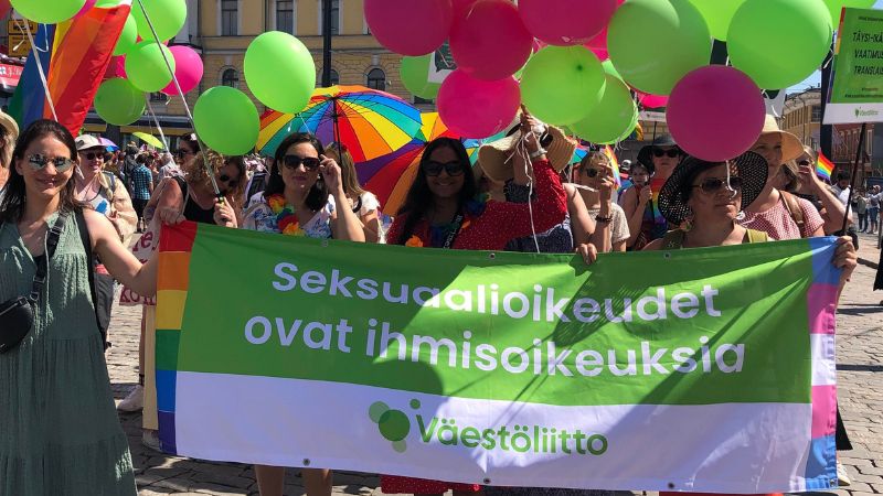 Väestöliittolaisia Senaatintorilla ennen Helsinki Pride -kulkuetta 2022. Banderollissa lukee "Seksuaalioikeudet ovat ihmisoikeuksia".